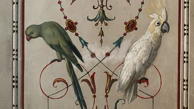 A green parakeet and a while cockatoo painted among grotesqueries