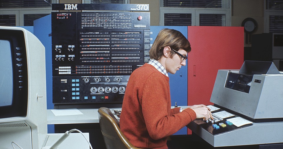 IBM-370 mainframe computer with a man punching cards