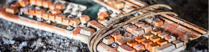 A broken orange keyboard covered in dirt