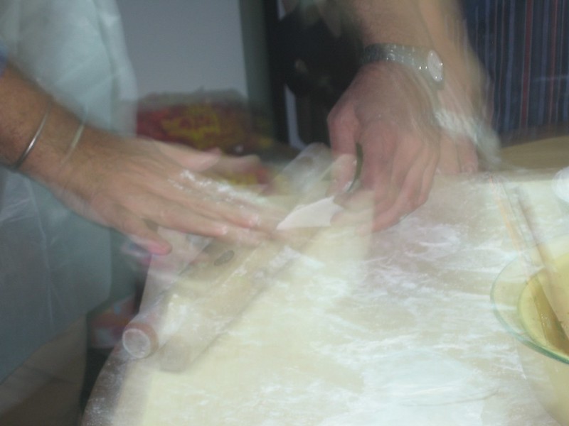 Motion blurred image of a woman rolling dumpling skins