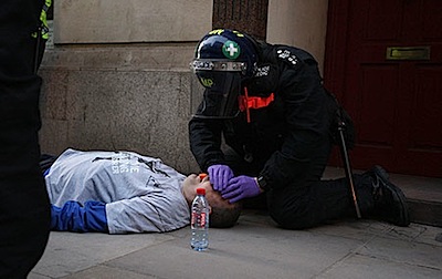 A police paramedic attends to Ian Tomlinson after he was attacked by police
