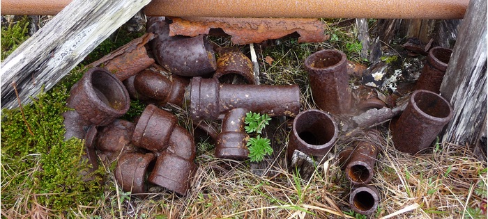 Rusty bits of pipework lying on the ground