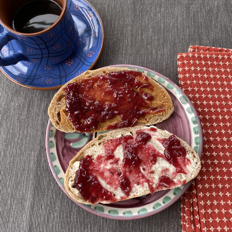 Grape jam on bread and butter and bread and peanut butter with coffee