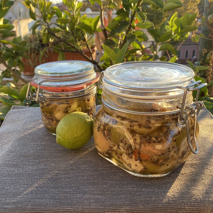 Two jars of lime pickle in front of the lime tree with an extra decorative lime