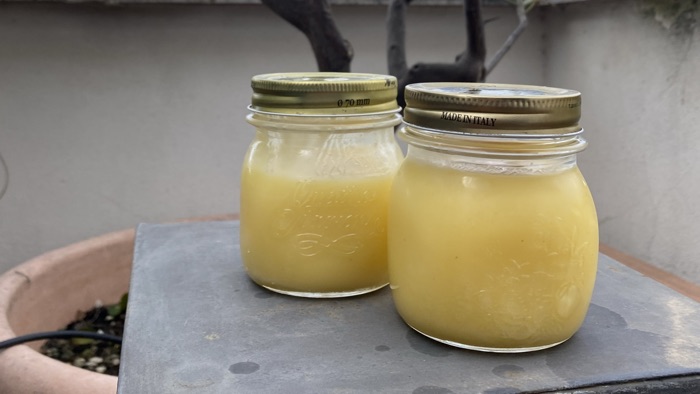 Two jars of sunny, yellow lemon curd