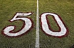 The number 50 painted onto grass at what I imagine must be the 50-yard line on a football field