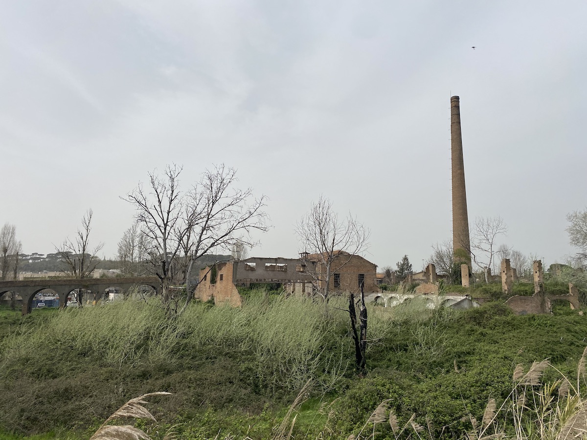 A tall brick-built chimney rises of the ruins of a former brickworks