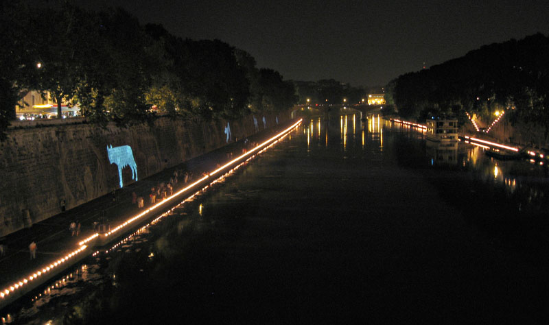 Night scene on the banks of the Tiber with the silhouette of a she-wolf projected onto the embankment