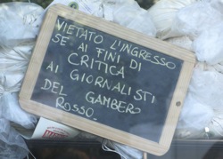 A chalked notice outside Pizzarium forbidding entrance to critics and journalists