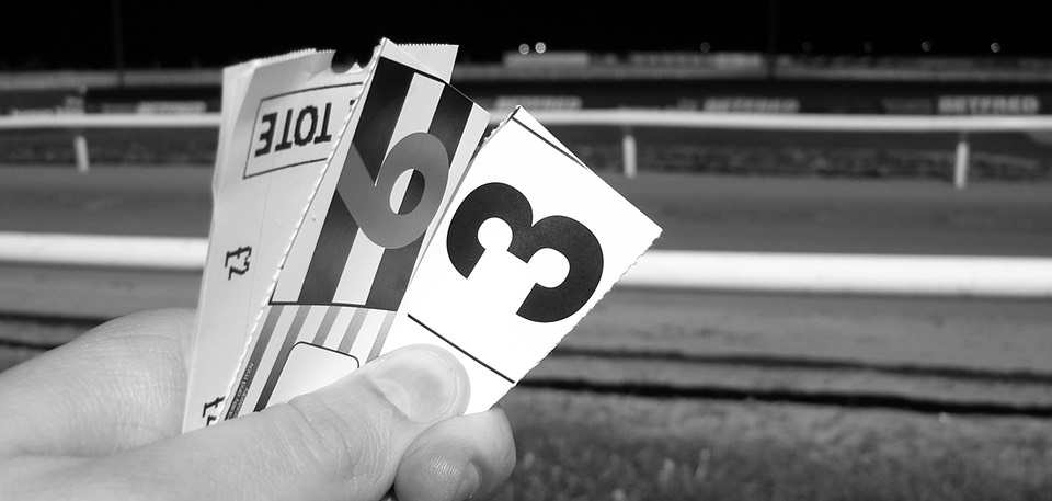 Monochrome betting slips in someone's hand