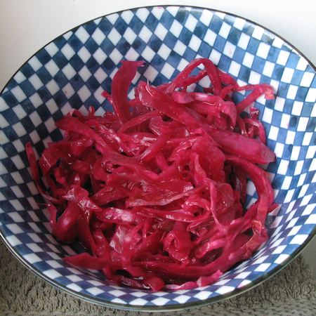 Blue and white checkered bowl with pink sauerkraut in it