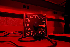 A stopwatch in the red light of a black and white darkroom