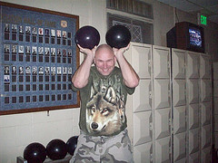 Man holding t2wo bowling balls up as Mickey Mouse ears