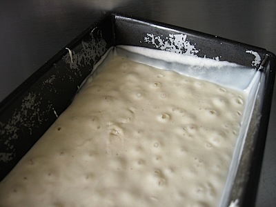 Very loose dough with a few bubbles in a loaf tin